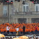 Ein großer Kinder- und Jugendchor in orangen T-Shirts auf einer Open-Air-Bühne.